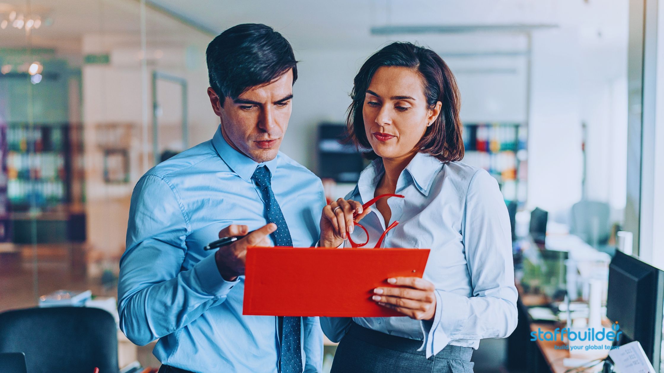 two employees talking about work while using a tablet device